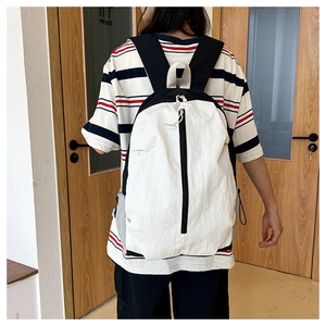 Detailed view of lightweight yoga backpack with black and white paneling and side pockets