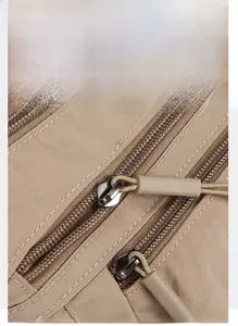Detail of durable nylon fabric and premium gold-plated metal zipper with textured puller