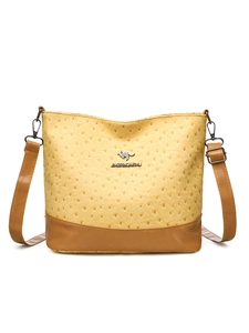 Detail of yellow ostrich texture Boston bag with brown leather corners and metal logo