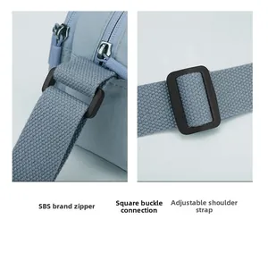 Detail view of SBS brand zippers and adjustable square buckles on light blue nylon bag