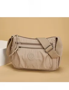 Detail view of khaki nylon multi-pocket shoulder bag with wide adjustable strap and zipper