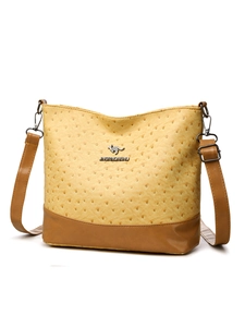 Detail of yellow ostrich texture Boston bag with metallic logo and brown panel
