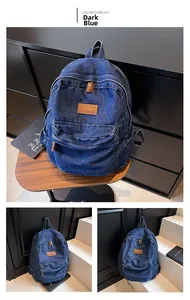 Detail of dark blue denim backpack with brown leather patches and large zipper pocket