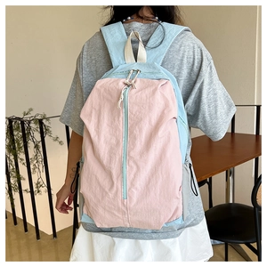 Detail of waterproof nylon yoga backpack showing pink and blue contrast stitching and dual zippers