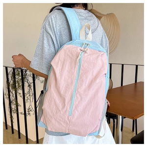 Rear view of a person wearing a pink and blue color-block waterproof yoga backpack