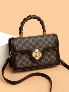 Detail of vintage square bag with M monogram leather and woven twist handle