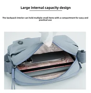 Detail view of the spacious inner compartment and pockets of the blue crossbody bag