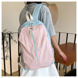 Detail view of the pink and light blue color-blocking yoga backpack with wrinkled texture