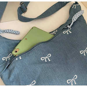 Blaue Denim-Umhängetasche mit weißen Schleifenmustern und Platz für ein Tablet innen