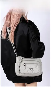 Détails du sac bandoulière gris clair en similicuir souple avec plusieurs poches zippées