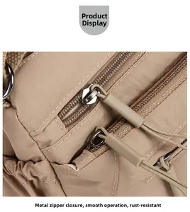 Close-up of durable double metal zippers on khaki canvas crossbody bag for women