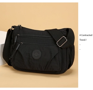 Detail view of durable black nylon crossbody bag with multi-layer zipper compartments