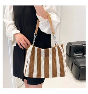 Detail of chunky knit tote with brown and white stripes and leather chain strap