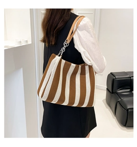 Detail of striped knit tote bag showing brown and white vertical texture and PU strap