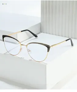 Detail of gold and black cat-eye glasses frame with sleek metal arms on white blocks