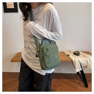 Army green nylon crossbody bag showing size scale and side fit on a model