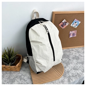 Close-up of waterproof tricolor nylon backpack with vertical zipper on wooden display