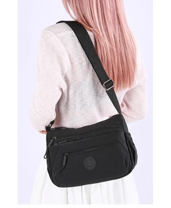 Detailed view of black nylon crossbody bag featuring multi-layer zipper pockets and adjustable strap