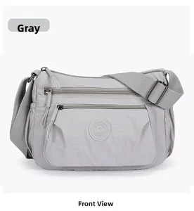 Close-up of waterproof grey nylon crossbody bag with multi-pocket front design
