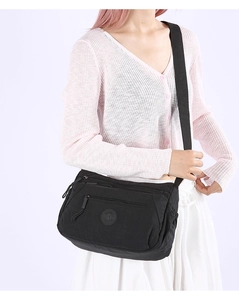 Detail of black nylon crossbody bag with multi-layer zipper pockets and logo