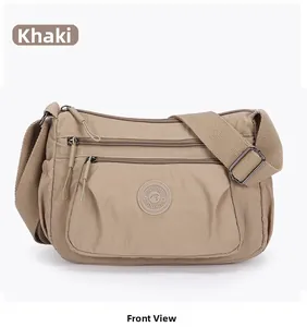 Front view of khaki nylon crossbody bag with multi-layer zippers and adjustable strap