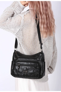 Détails du sac à bandoulière en cuir PU noir souple avec poches zippées et breloque en cœur