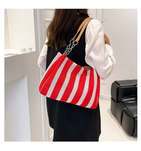 Detail of red and white striped woven tote bag with leather and silver chain straps