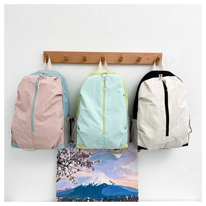 Detailed view of lightweight nylon yoga backpacks in pink, mint green and black colors