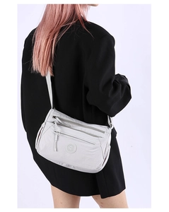 Close-up of light gray waterproof nylon crossbody bag with multiple zip pockets and adjustable strap