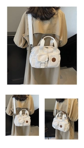 Detail view of white canvas crossbody bag featuring multi-pocket design and leather logo patch