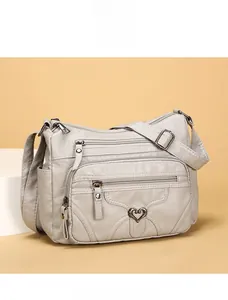 Détail de la sacoche grise multi-poches en cuir souple avec texture grainée et zip