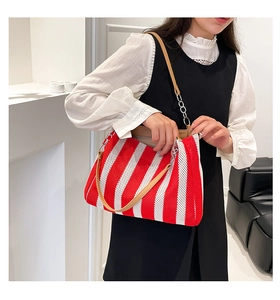 Close-up of red and white striped mesh tote bag with brown leather and silver chain strap