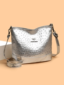 Detail of silver ostrich texture leather surface with metallic kangaroo logo on bag