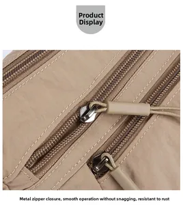 Close-up of smooth double hardware zippers on a waterproof nylon shoulder bag