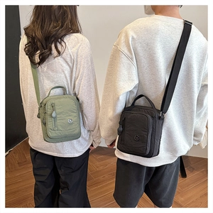 Detail view of the waterproof nylon crossbody bag with adjustable strap and dual zipper compartments