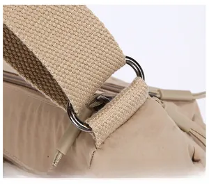 Detail of durable nylon bag with wide woven shoulder strap and silver metal D-ring buckle