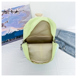 Internal view of the green yoga backpack showing multiple compartments and storage space
