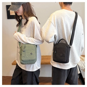 Detail view of nylon crossbody bags in olive green and black with adjustable straps