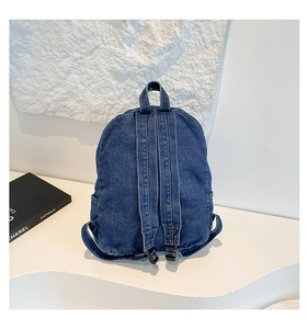 Rear view of denim backpack showing wide shoulder straps and adjustable plastic buckles