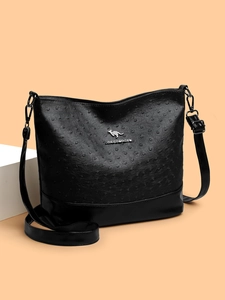 Close-up of black glossy embossed leather texture and silver kangaroo logo on bag