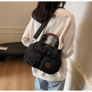Detail view of water-resistant black nylon crossbody bag with multi-pocket design