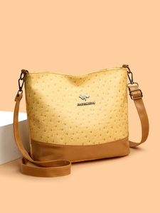 Detail of ostrich texture faux leather bag with adjustable strap and metal kangaroo logo