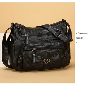Détail du sac bandoulière en cuir PU noir souple avec zips et fermoir en forme de cœur