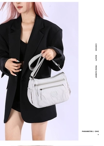 Close-up of waterproof nylon crossbody bag featuring multi-layer zipper pockets and wide strap