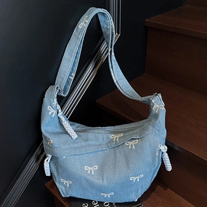 Sac hobo en denim bleu à motif nœuds blancs sur escalier en bois, style décontracté