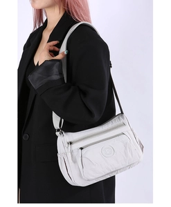 Detailed view of grey nylon multi-layer crossbody bag with adjustable strap and zip pockets