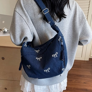 Sac bandoulière en denim avec motifs nœuds blancs, design hobo élégant et moderne