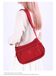 Practical red nylon crossbody bag with multiple pockets shown on model for size and fit