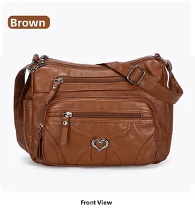 Vue de face d'un sac bandoulière marron avec plusieurs poches zippées et boucle coeur argent