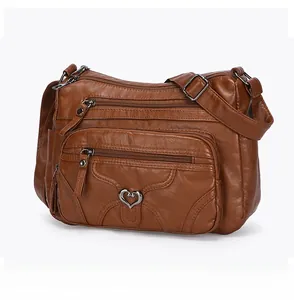 Vue latérale d'un sac bandoulière en cuir PU marron avec plusieurs poches zippées